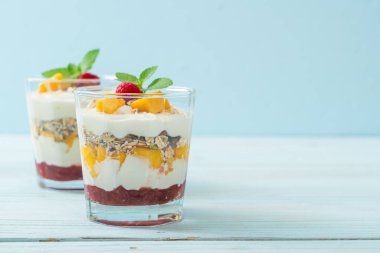 Ev yapımı taze mango ve yoğurt ve granola ile taze ahududu. Sağlıklı yemek tarzı.