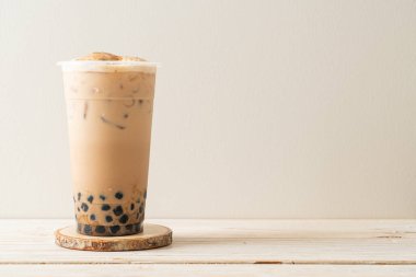 Tahta masada yanmış köpüklü ve peynirli Tayvan sütü çayı.