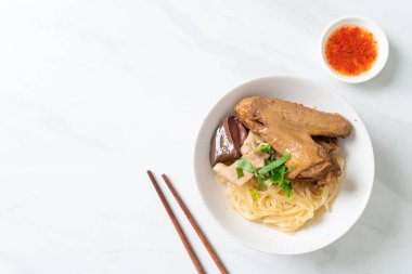 Beyaz kasede pişmiş ördekle kurutulmuş şehriye. Asya usulü.