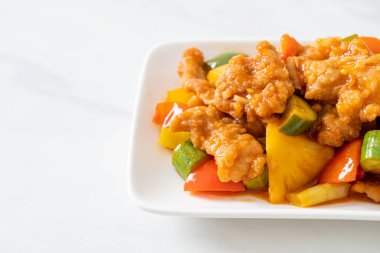 Kızarmış tatlı ve ekşi sosla domuz ve sebzeyi karıştır.