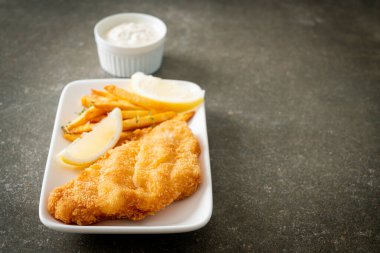 balık ve patates kızartması - kızarmış balık fileto patates cipsi ve limonlu beyaz tabak