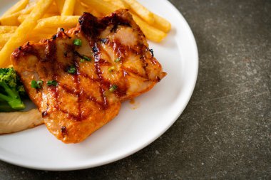 grilled chicken steak with potato chips or french fries on white plate