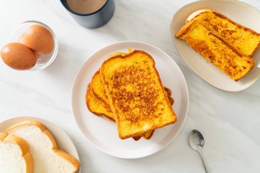 Kahvaltı için beyaz tabakta yumurtalı ekmek.