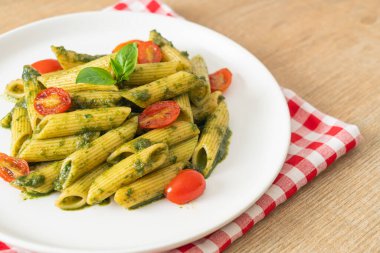 Pesto soslu ve domatesli makarna. Vejetaryen ve vejetaryen yemek tarzı.