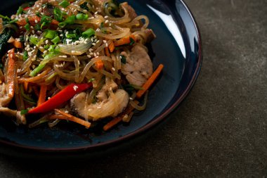 Japchae ya da karışık Kore vermicelli erişte sebzeli ve üzerine beyaz susamlı domuz eti - Kore geleneksel yemek tarzı