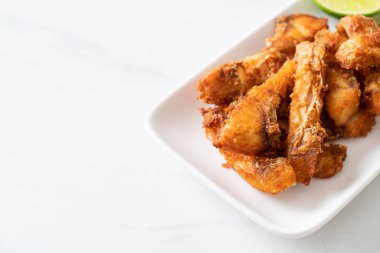 Fried Snapper Belly on white plate - Asian food style