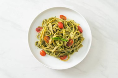 pesto soslu ve domatesli makarna vejetaryen ve vejetaryen yemek tarzı.