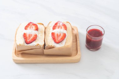 gözlemeli sandviç, çilekli taze krema, ahşap tabakta.