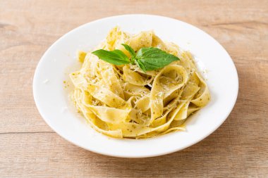 Pesto fettuccine makarna, üstüne de parmesan peyniri.