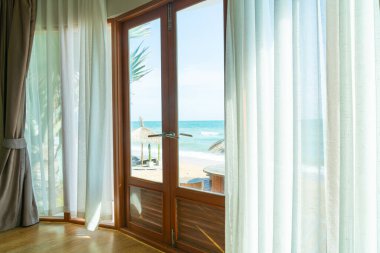 curtain and glass window with beautiful sea beach view outside