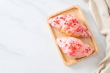 Tahta tabakta çilekli çikolata soslu kruvasan.