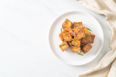 Beyaz susamlı kızarmış tofu ve teriyaki sosu. Vejetaryen ve vejetaryen yemek tarzı.