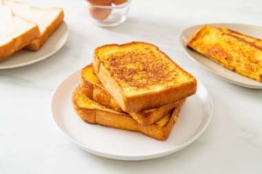 Kahvaltı için beyaz tabakta yumurtalı ekmek.