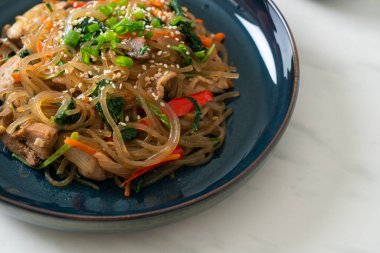 Japchae ya da karışık Kore vermicelli erişte sebzeli ve üzerine beyaz susamlı domuz eti - Kore geleneksel yemek tarzı