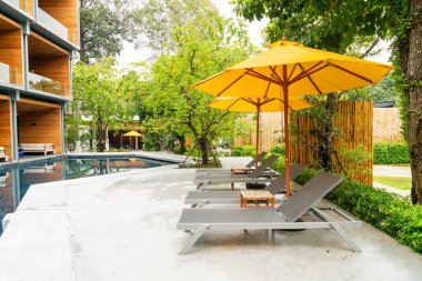 Otelin havuzunda havuz çevresinde şemsiye ve bilardo takımı.