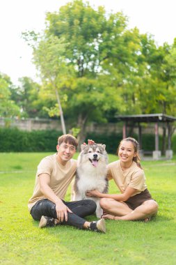 Asian couple love with cute dog in garden