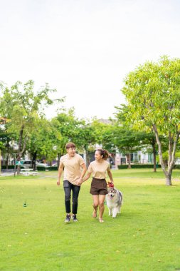 Asian couple love with cute dog in garden
