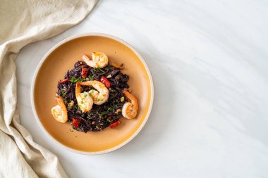 Sarımsaklı ve karidesli kızarmış siyah spagetti.