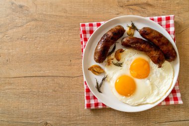 Kahvaltıda omlet ve kızarmış domuz sosisi.