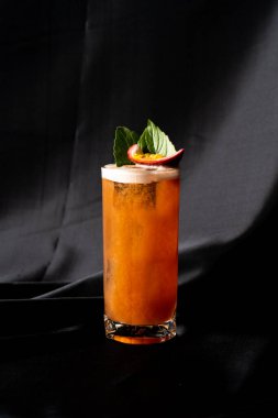 Kokteyl - fesleğen, tutku meyvesi ve tarçın, limon ve mango karıştırılmış koyu arkaplanda.