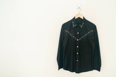 Duvarında ahşap askı asılı güzel bir kadın gömleği.