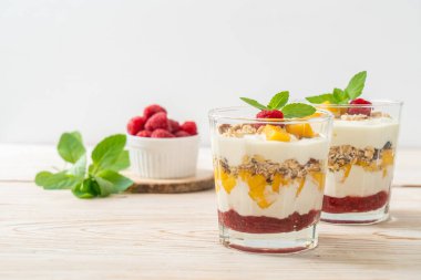 Ev yapımı taze mango ve yoğurt ve granola ile taze ahududu. Sağlıklı yemek tarzı.