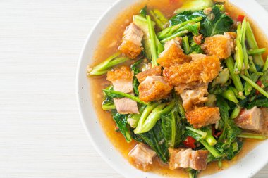 Kızarmış lahana sebzesi ve kıtır domuz eti Asya yemeği.