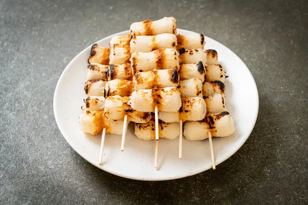 grilled tube shaped fish paste cake or tube squid skewer on plate