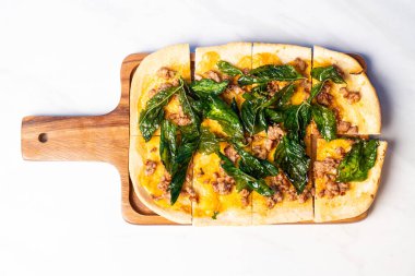 Tahtada fesleğenli pizza ve kıymalı turta.