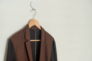 dark brown suit hanging with wood hanger on wall