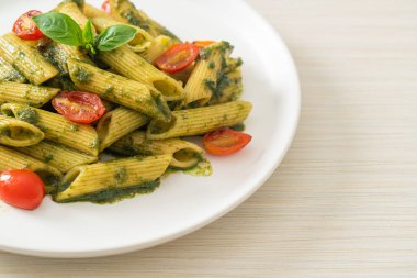 Pesto soslu ve domatesli makarna. Vejetaryen ve vejetaryen yemek tarzı.