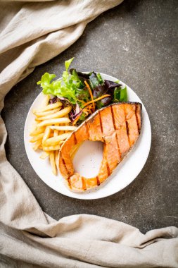 Kızarmış somon bifteği fileto, sebze ve patates kızartması.