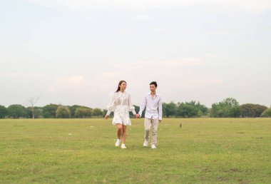 Gelin ve damat kıyafetli mutlu genç Asyalı çift evlenmeye ve evlenmeye hazır.