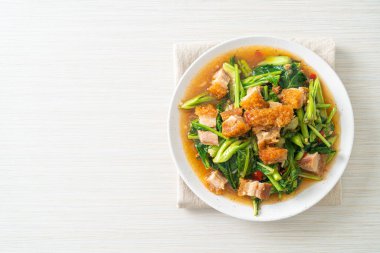 Kızarmış lahana sebzesi ve kıtır domuz eti Asya yemeği.