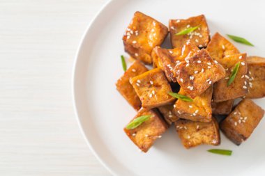 Beyaz susamlı kızarmış tofu ve teriyaki sosu. Vejetaryen ve vejetaryen yemek tarzı.