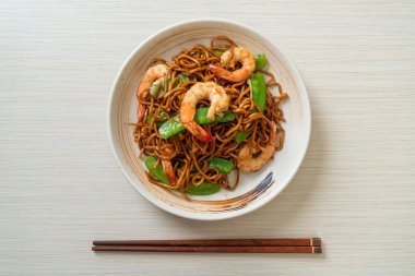 Kızarmış yakisoba eriştesi, yeşil bezelye ve karides, Asya usulü.