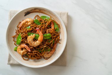 Kızarmış yakisoba eriştesi, yeşil bezelye ve karides, Asya usulü.