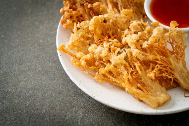 Kızarmış enoki mantarı ya da baharatlı soslu altın iğneli mantar - vejetaryen yemek tarzı.