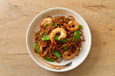 Kızarmış yakisoba eriştesi, yeşil bezelye ve karides, Asya usulü.