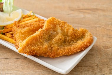 balık ve patates kızartması - kızarmış balık fileto patates cipsi ve limonlu beyaz tabak