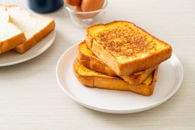 Kahvaltı için beyaz tabakta yumurtalı ekmek.