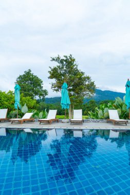 pool bed around swimming pool with mountain hill background - Holidays and vacation concept