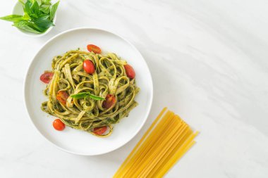 pesto soslu ve domatesli makarna vejetaryen ve vejetaryen yemek tarzı.