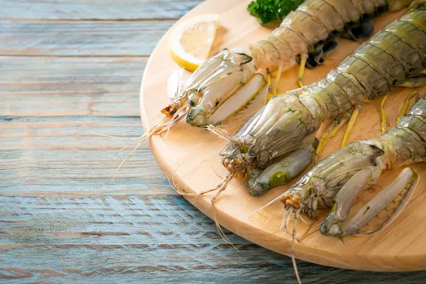 stock image fresh mantis shrimp with lemon on wood board