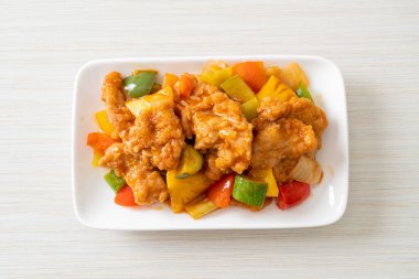 Kızarmış tatlı ve ekşi sosla domuz ve sebzeyi karıştır.