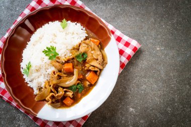 Dilimlenmiş domuz eti, havuç ve soğanlı Japon körili pilavı. Asya usulü.