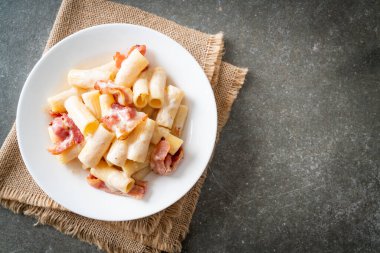 Beyaz soslu ve pastırmalı ev yapımı spagetti rigatoni makarna. İtalyan usulü.