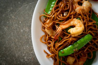 Kızarmış yakisoba eriştesi, yeşil bezelye ve karides, Asya usulü.