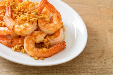 Kızarmış karides ya da beyaz tabakta sarımsaklı karides - deniz ürünleri tarzı.