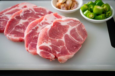 Taze domuz boyunlu ya da yakalı domuz eti ve terbiye edilecek malzemeler.